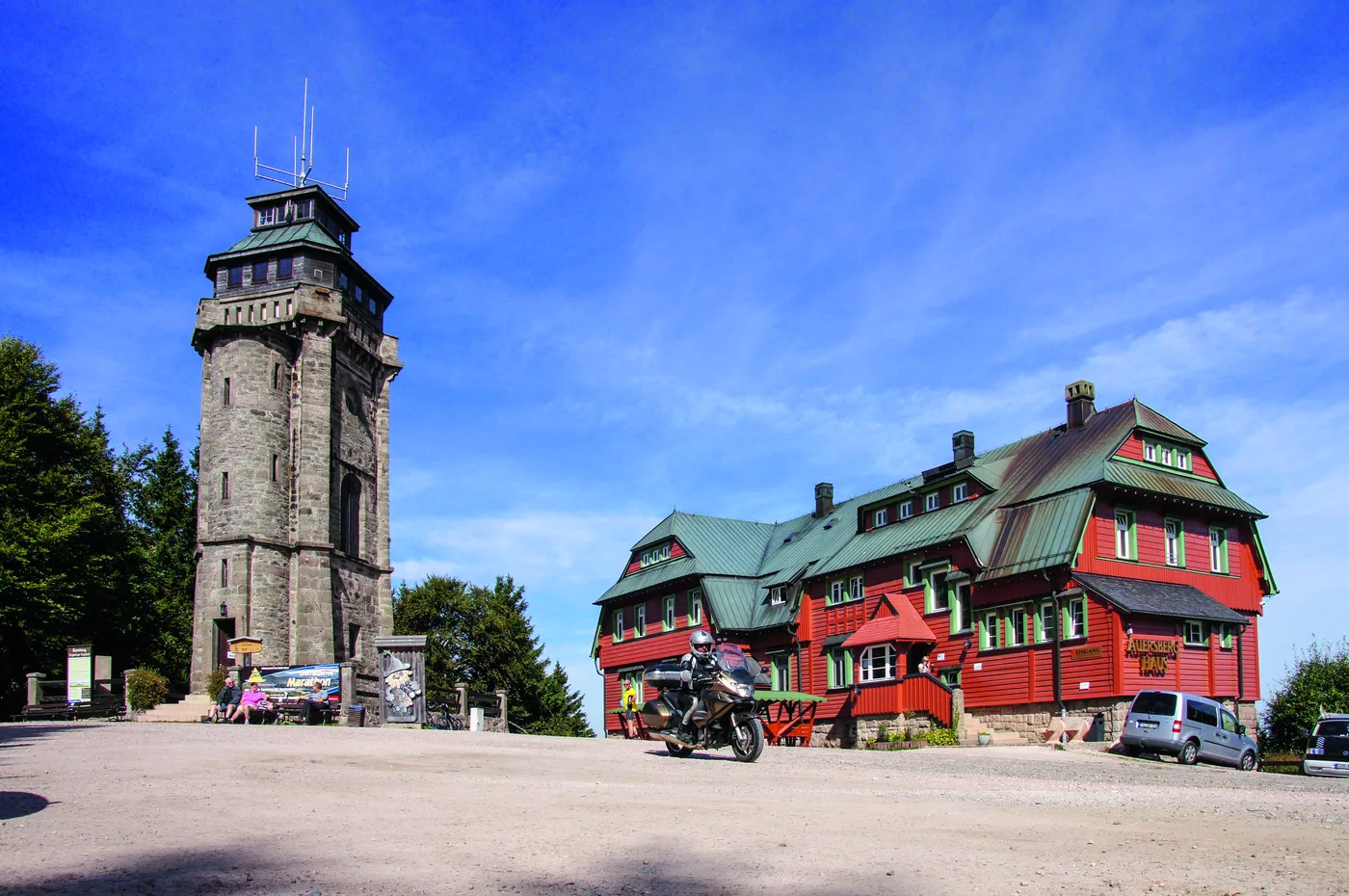 Steinerner Aussichtsturm und rotes Auersberghaus auf dem Gipfel des Auersbergs